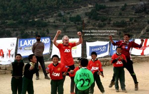 Kids in oversized Manchester United jerseys play football in a school ground in Namche with some participants and Everest Marathon team. It was a charity match where kids received player worn jerseys directly from Manchester United.